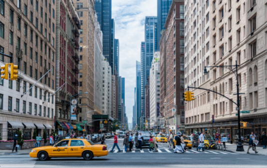 New York Nonprofit Staffing & Recruiting Agency image of intersection of New York City with people crossing street in front of taxi