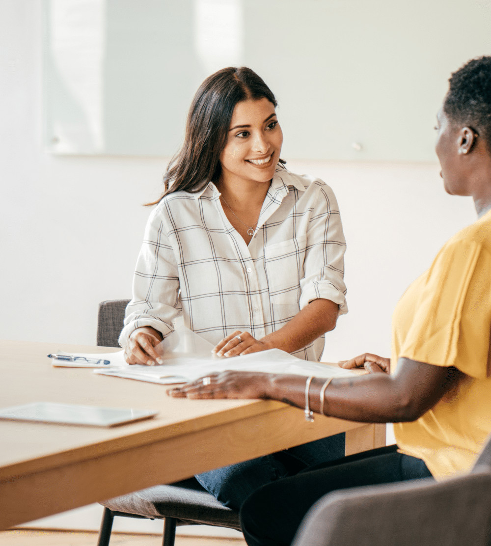 How to Ensure You're a Top-Notch Nonprofit Candidate - image of a female nonprofit candidate meeting with a female nonprofit hiring manager